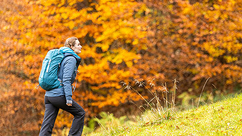Wandern im Herbst auf der Kampenwand. Wegen der schwankenden Temperaturen im Schatten und in der Sonne sollte Bergfreunde mehrere Schichten Kleidung tragen, die bei Bedarf an- oder ausgezogen werden kann.