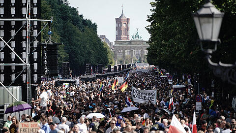 Demonstration gegen die Corona-Maßnahmen auf der Straße des 17. Juni in Berlin. Im Hintergrund das Brandenburger Tor und das Rote Rathaus.