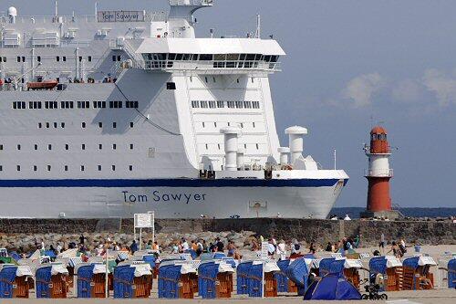 Ein Fährschiff läuft vor blauem Himmel in Rostock-Warnemünde ein