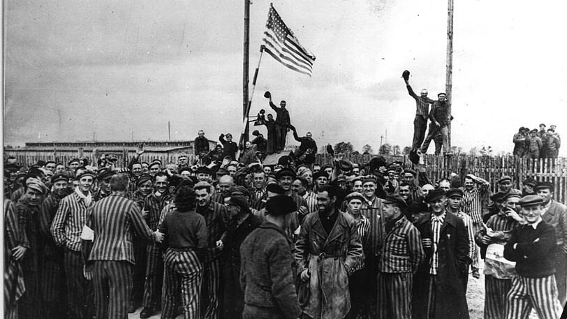 US-Soldaten und Gefangene hissen die amerikanische Flagge.