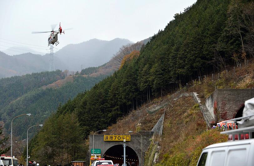Ein Rettungshubschrauber fliegt über dem Tunneleingang.