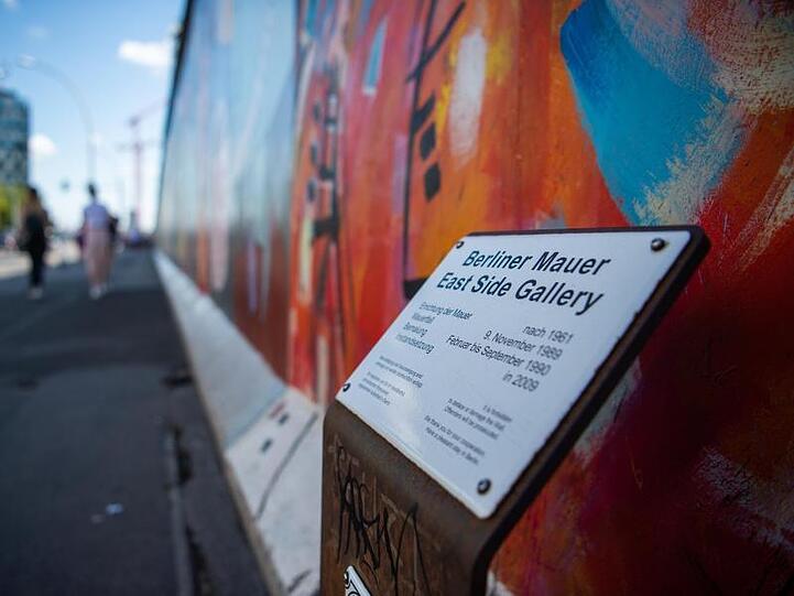 Ein Schild erklärt die historischen Hintergründe der East Side Gallery.