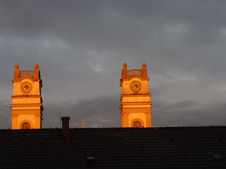 "Ein Schnappschuß aus Untersendling, wo die beiden Glockentürme der 'St. Korbinian-Kirche' im herbstlichen Abendrot erstrahlen."
