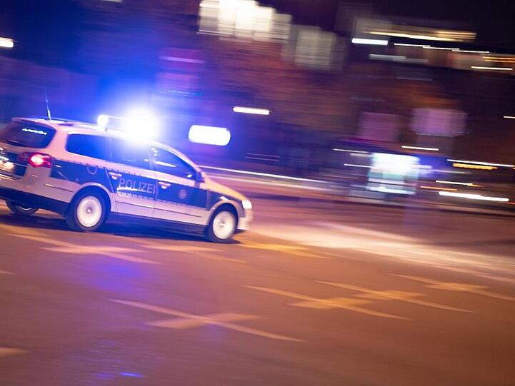 Ein Polizeiauto fährt unter Einsatz von Blaulicht und Sirene eine Straße entlang. Foto: Lino Mirgeler/dpa/Symbolbild