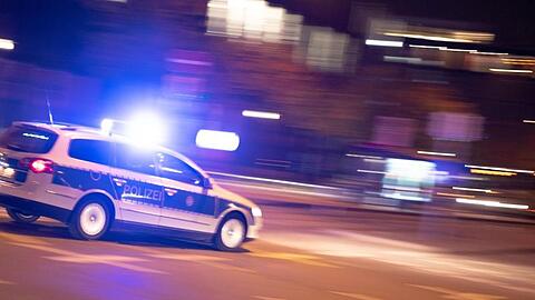 Ein Polizeiauto fährt unter Einsatz von Blaulicht und Sirene eine Straße entlang. Foto: Lino Mirgeler/dpa/Symbolbild