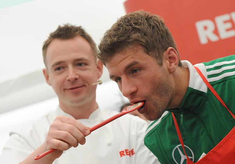 Holger Stromberg fütter Bayern-Star Thomas Müller bei einem Sponsorentermin.