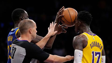 Golden State Warriors-Forward Draymond Green (l) schiebt den Ball dem Lakers-Guard Dennis Schröder (17) ins Gesicht.