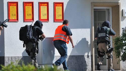 Beamte stürmen das haus, in dem sich der Bombenleger verschanzt hat. Beamte stürmen das haus, in dem sich der Bombenleger verschanzt hat.