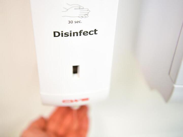 Auf der Toilette im Brandenburger Ministeriums für Soziales, Gesundheit, Integration und Verbraucherschutz ist eine Box mit der Aufschrift &bdquo;Disinfect&ldquo; zum Desinfizieren der Hände an der Wand installiert.