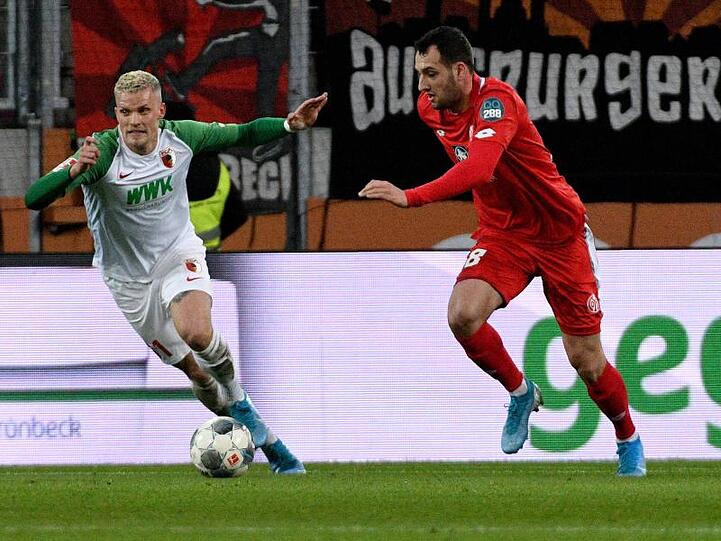 Augsburgs Philipp Max und der Mainzer Levin Mete Öztunali (l-r.) im Zweikampf um den Ball. Foto: Stefan Puchner/dpa