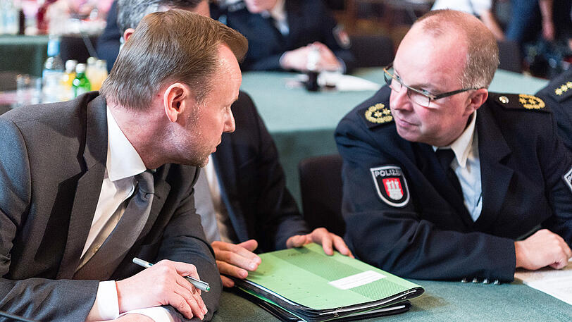 Hamburgs Innensenator Andy Grote (SPD, links) lehnt sich im Hamburger Rathaus während einer Sondersitzung des Innenausschusses der Bürgerschaft zum Sicherheitskonzept und der Einsatztaktik beim G20-Gipfel, zum Leitenden Polizeidirektor der Polizei Hamburg, Hartmut Dudde, herüber.