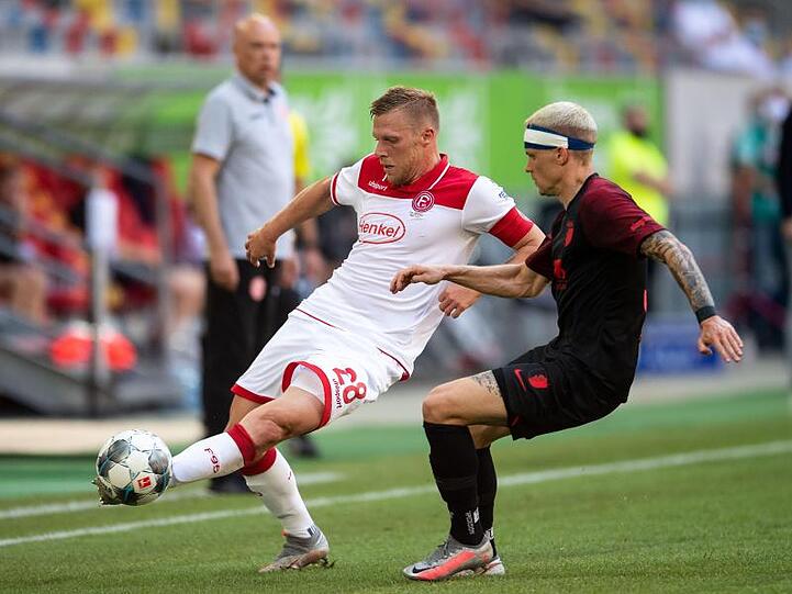 Düsseldorfs Rouwen Hennings (l) und Augsburgs Philipp Max kämpfen um den Ball. Foto: Marius Becker/dpa
