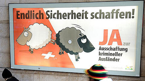 Ein Mann geht am Hauptbahnhof von Basel an einem Plakat der Schweizerischen Volkspartei (SVP) vorbei, auf dem die Ausweisung (Ausschaffung) krimineller Ausländer gefordert wird.