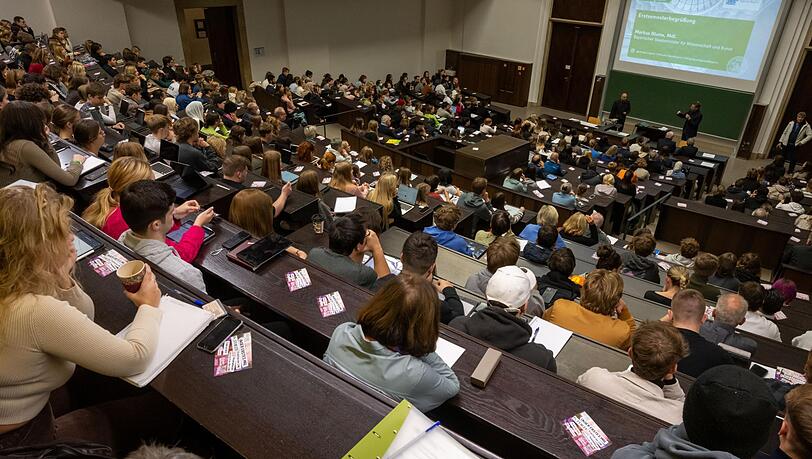 Studierende nehmen an der Einf&uuml;hrungsveranstaltung im Audimax der Ludwig-Maximilians-Universit&auml;t (LMU) teil. Ein Professor verdient als Grundgehalt zwischen 5500 und 8600 Euro.