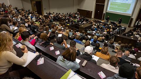 Studierende nehmen an der Einf&uuml;hrungsveranstaltung im Audimax der Ludwig-Maximilians-Universit&auml;t (LMU) teil. Ein Professor verdient als Grundgehalt zwischen 5500 und 8600 Euro.