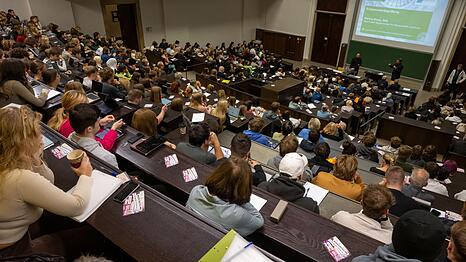 Studierende nehmen an der Einf&uuml;hrungsveranstaltung im Audimax der Ludwig-Maximilians-Universit&auml;t (LMU) teil. Ein Professor verdient als Grundgehalt zwischen 5500 und 8600 Euro.