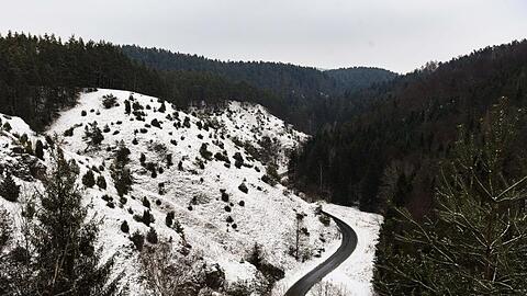 Eine Landstraße schlängelt sich durch das schneebedeckte Tal. Foto: Nicolas Armer