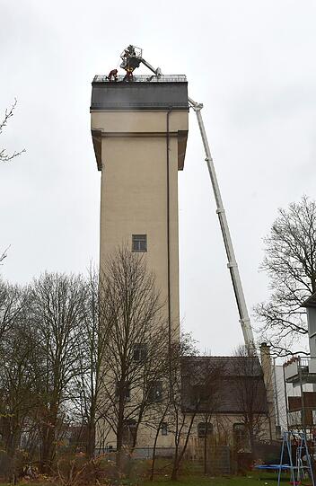Einsatz in luftiger Höhe: Einsatzkräfte der Berufsfeuerwehr befestigen das gelöste Teil des Bechdaches.
