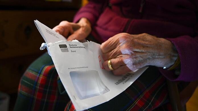 Eine Seniorin hält ihren Rentenbescheid in der Hand. Viele Renten sind niedrig - aber sind die Bezieher wirklich arm?
