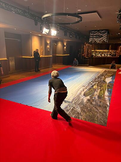 Das riesige B&uuml;hnenbild der Fastenpredigt wird im Foyer w&auml;hrend des Singspiels vorsichtig eingepackt.