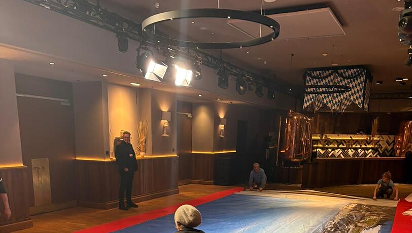 Das riesige B&uuml;hnenbild der Fastenpredigt wird im Foyer w&auml;hrend des Singspiels vorsichtig eingepackt.