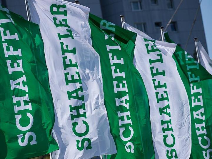 Fahnen mit dem Logo-Schriftzug der Schaeffler AG. Foto: Daniel Karmann/dpa/Archivbild