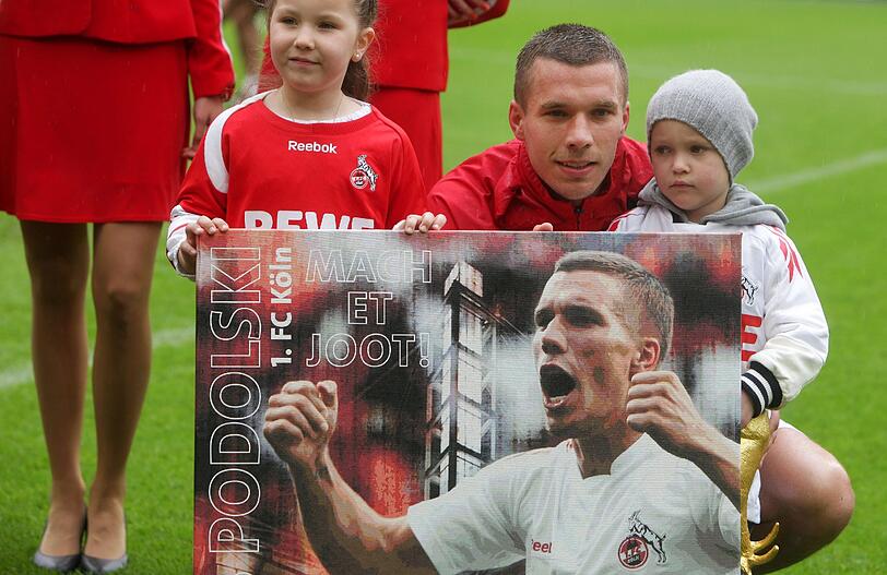Podolski nimmt ein Geschenk des Vereins entgegen.