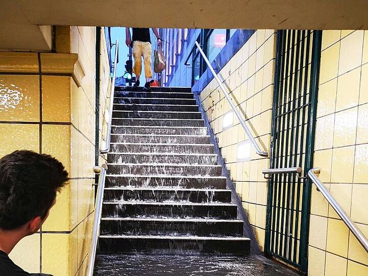 In Berlin läuft nach heftigen Gewittern Regenwassser in die U-Bahn-Station Friedrichstraße.