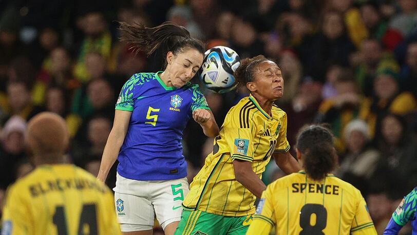 Die Brasilianerin Luana (l) und die Jamaikanerin Atlanta Primus (M) liefern sich ein Kopfballduell.