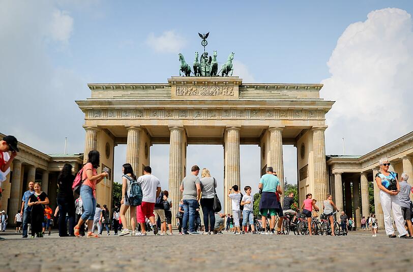 Touristen stehen in Berlin vor dem Brandenburger Tor. Foto: Kay Nietfeld