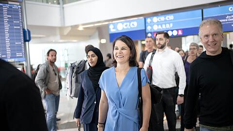 Außenministerin Annalena Baerbock (M, Bündnis 90/Die Grünen) ist auf dem Flughafen in Dubai auf dem Weg zu ihrem Flug.
