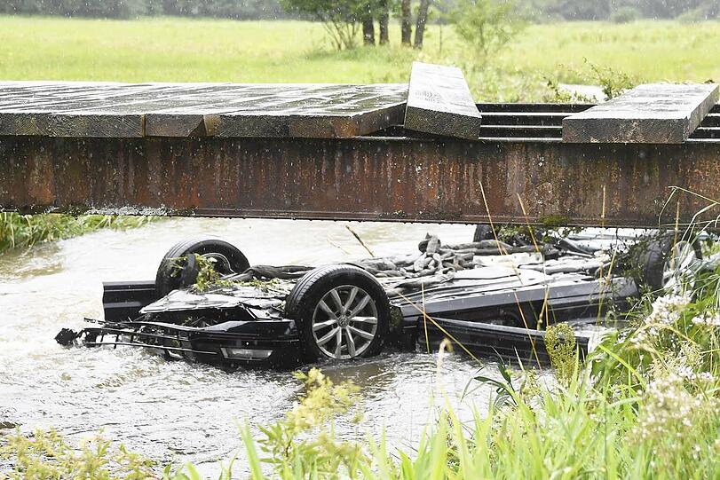 Bei Bayerischzell am Schliersee landet ein Passat kopfüber in einem stark überfluteten Bach. Der Fahrer kann in letzter Sekunde gerettet werden. Die Bilder des Unfalls.