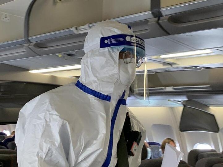 Ein Beamter der chinesischen Gesundheitsbehörde begleitet den Sonderflug, um die Körpertemperatur von Passagieren zu messen und nach Krankheitssymptomen zu fragen.