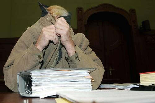 Der Angeklagte Hartmut O. (64) verbirgt sein Gesicht.