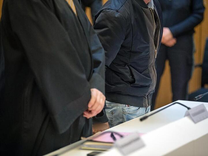 Einer der Angeklagten im Prozess um den Raubmord von Meiling steht neben einem Anwalt (l) im Gerichtssaal. Foto: Lino Mirgeler