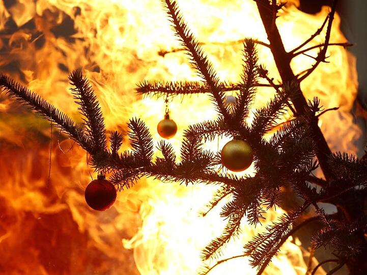 Ein brennender Weihnachtsbaum. Foto: Roland Weihrauch/dpa/Archivbild