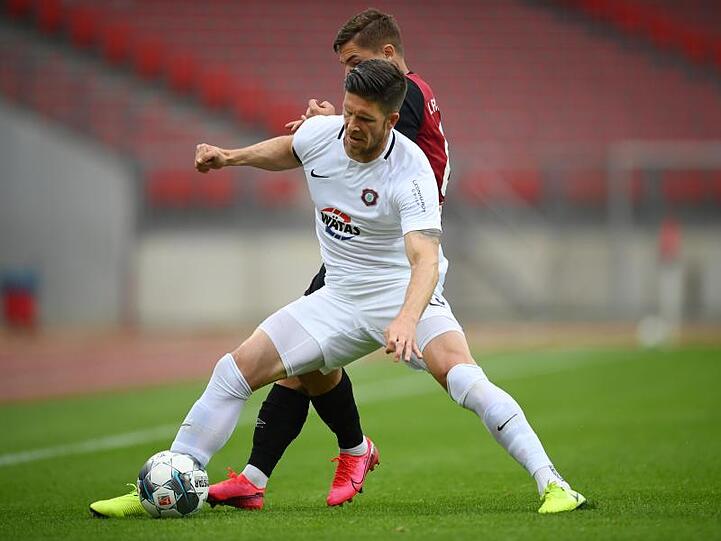 Dennis Kempe aus Aue (v) schirmt den Ball gegen Nikola Dovedan ab.