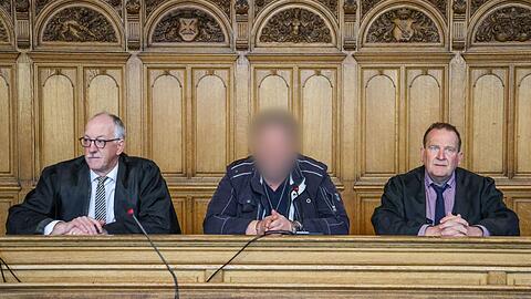 Der Angeklagte (M) sitzt vor der Urteilsverkündung im Prozess wegen Mordes im Landgericht Bremen zwischen seinen Verteidigern.