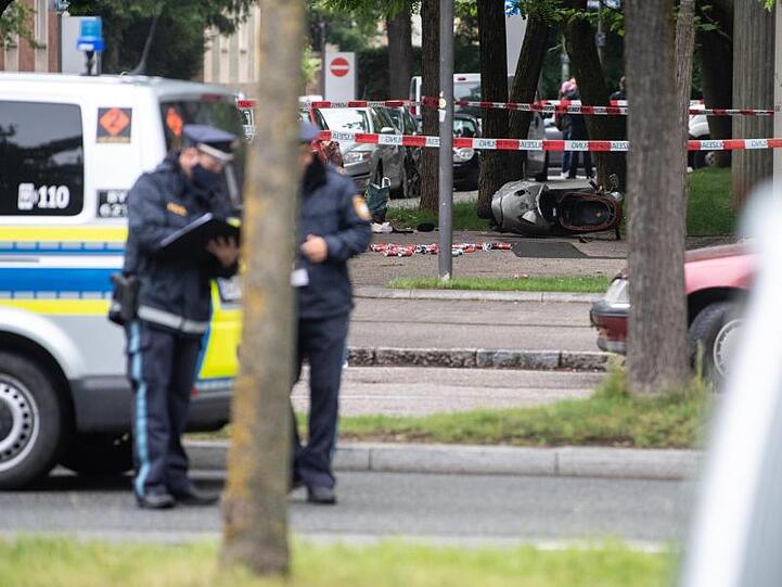 Etliche Dosen und ein umgekippter Roller liegen an der Stelle, an der ein Fahrzeug in eine Gruppe von Menschen gefahren ist.