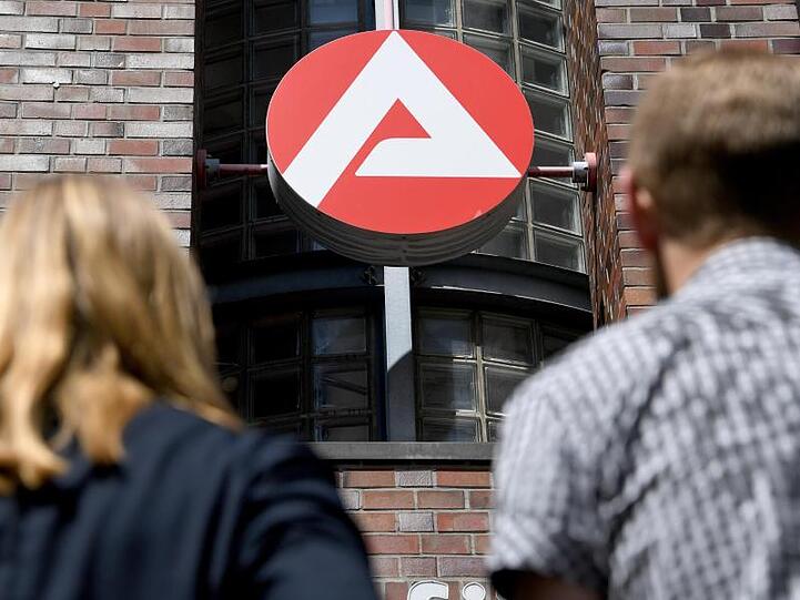 Vor dem Logo der Agentur für Arbeit.