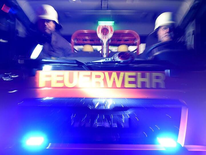 Feuerwehrmänner in einem Löschfahrzeug. Foto: Carsten Rehder/dpa/Symbolbild