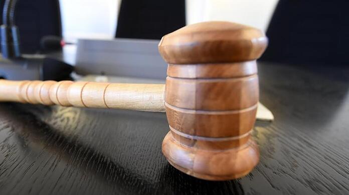 Auf der Richterbank liegt am ein Richterhammer aus Holz.