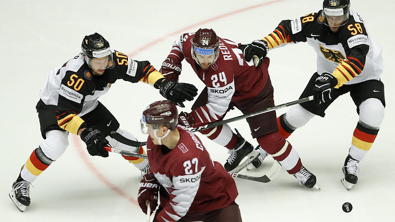 Die DEB-Spieler Patrick Hager (l) und Markus Eisenschmid (r) versuchen an den Puck zu kommen.