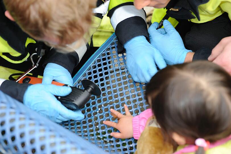 Mit einer kleinen Kreissäge befreiten die Einsatz-Kräfte die Dreijährige, die während der Aktion tapfer ihren Teddy im Arm hielt.