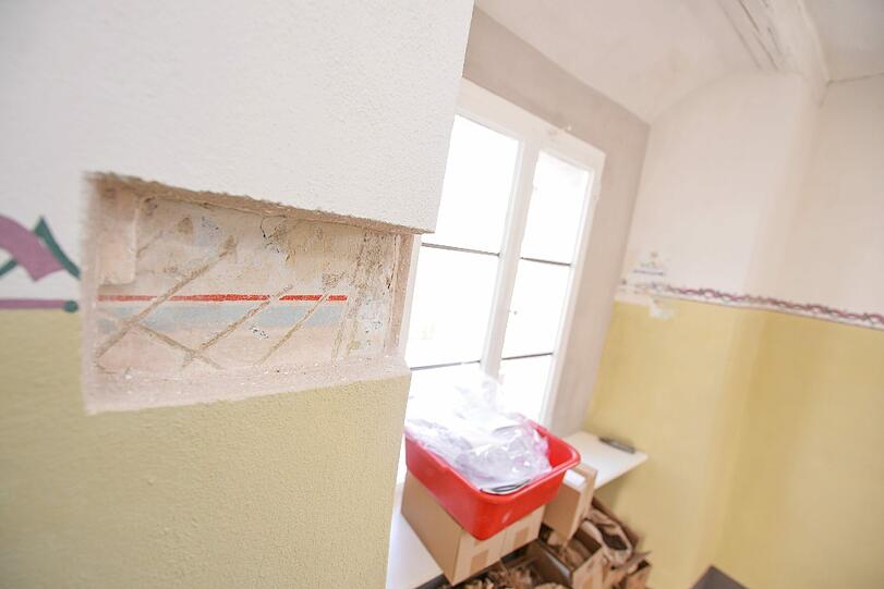 Eine Aussparung gibt den Blick auf die ursprüngliche Wandverzierung frei.