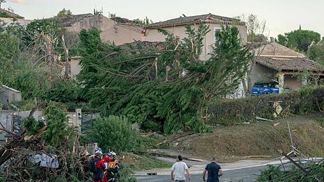 Nach dem Tornado untersuchen Einsatzkr&auml;fte die H&auml;user in der Gemeinde.
