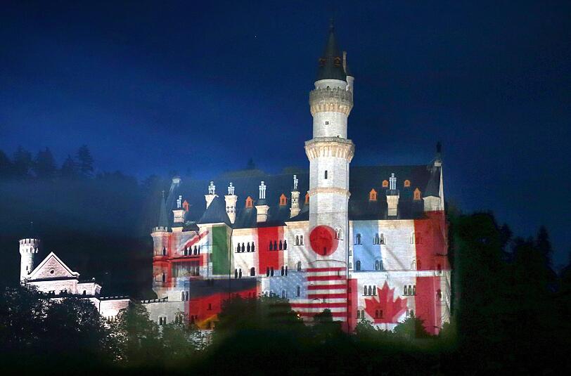Zeichen der Gastfreundschaft: Auf das Schloss Neuschwanstein bei
Hohenschwangau werden Fotos der Landesfahnen der G7-Mitglieder
projiziert.