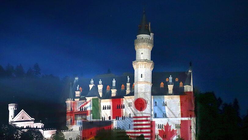 Zeichen der Gastfreundschaft: Auf das Schloss Neuschwanstein bei
Hohenschwangau werden Fotos der Landesfahnen der G7-Mitglieder
projiziert. Zeichen der Gastfreundschaft: Auf das Schloss Neuschwanstein bei
Hohenschwangau werden Fotos der Landesfahnen der G7-Mitglieder
projiziert.