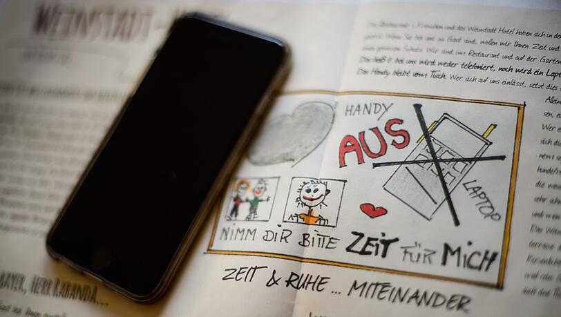 Ein Handy liegt auf einer Broschüre mit der Aufforderung "Handy aus". Im Weinstadt- Hotel sind Handys und Laptops verboten - zumindest im Frühstückssaal, auf der Sonnenterrasse und im angrenzenden Restaurant. Ein Handy liegt auf einer Broschüre mit der Aufforderung "Handy aus". Im Weinstadt- Hotel sind Handys und Laptops verboten - zumindest im Frühstückssaal, auf der Sonnenterrasse und im angrenzenden Restaurant.