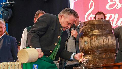 Zwei Schläge braucht der Wirtschaftsreferent Christian Scharpf (SPD) beim Anstich auf dem Frühlingsfest 2025 in der Festhalle Bayernland.